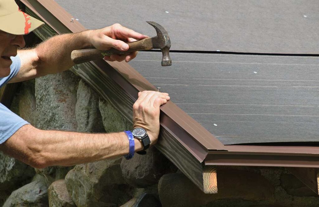 A close-up of a residential asphalt roof with curled and cracked shingles under daylight.